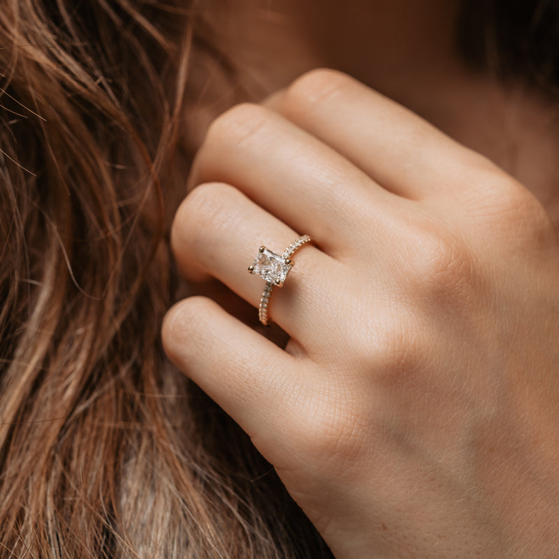 model wearing radiant cut engagement ring with side stones set into shoulders luxury cornish jewellery