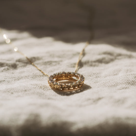 Diamond Circle Necklace in yellow gold on linen cloth