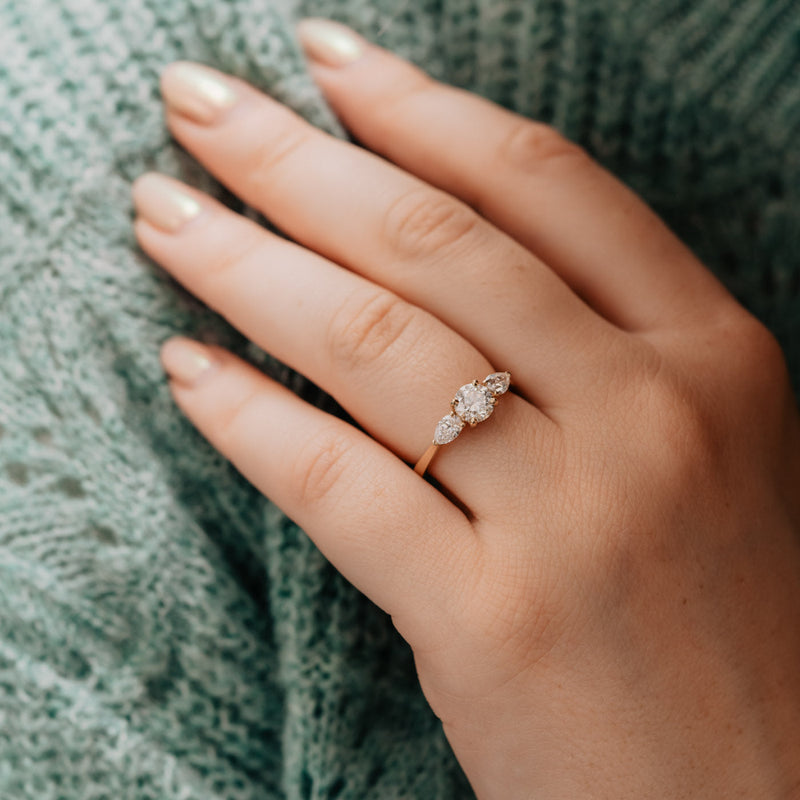 The Georgia by Ethica Diamonds – round engagement ring with pear side stones set into recycled gold