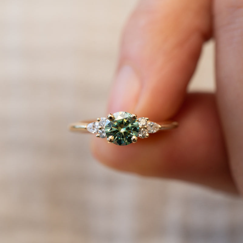 Timeless round accented engagement ring with faint green diamond centre and round pear side diamonds
