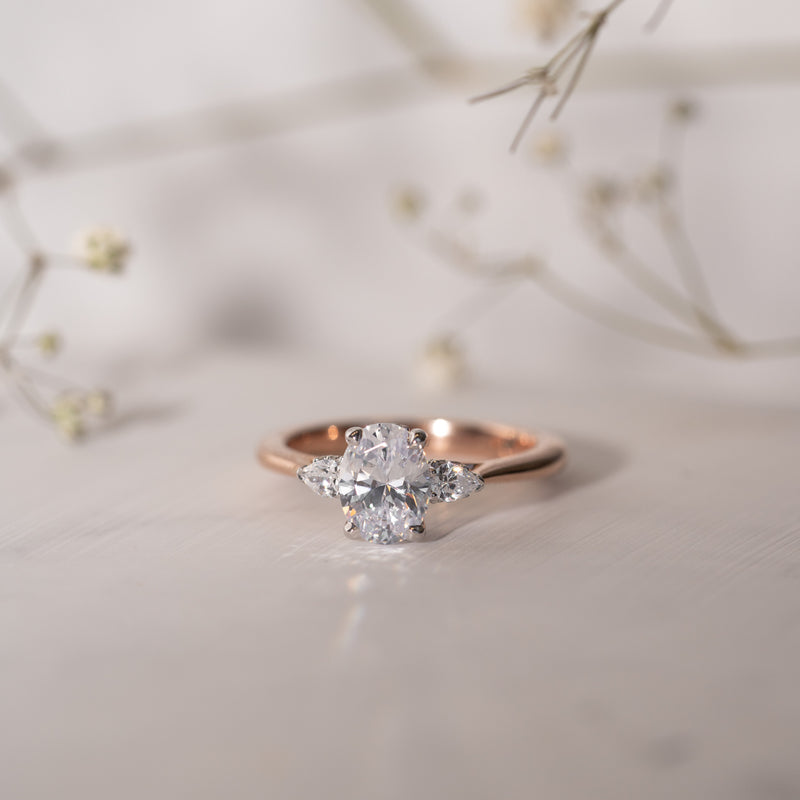 Marina Ring with centre oval diamond with pear side stones, and subtle hidden halo in white & rose gold