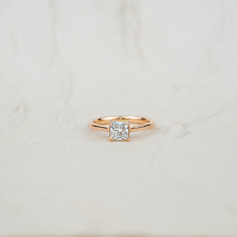 Rose gold princess solitaire engagement ring the paris by ethica diamonds on a neutral white background