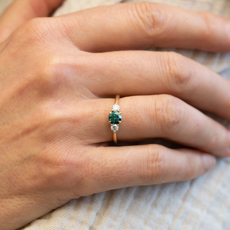 Trilogy engagement band with lab grown and dark green moissanite ring in yellow gold
