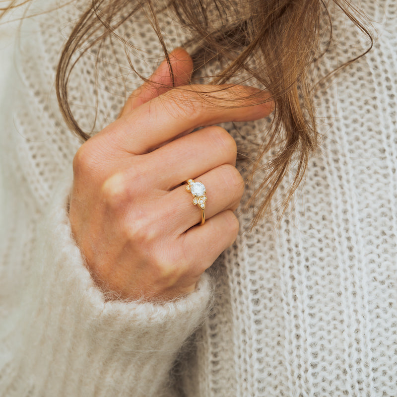 Model wears lab diamond blooming flower engagement ring with carbon negative diamonds made in cornwall