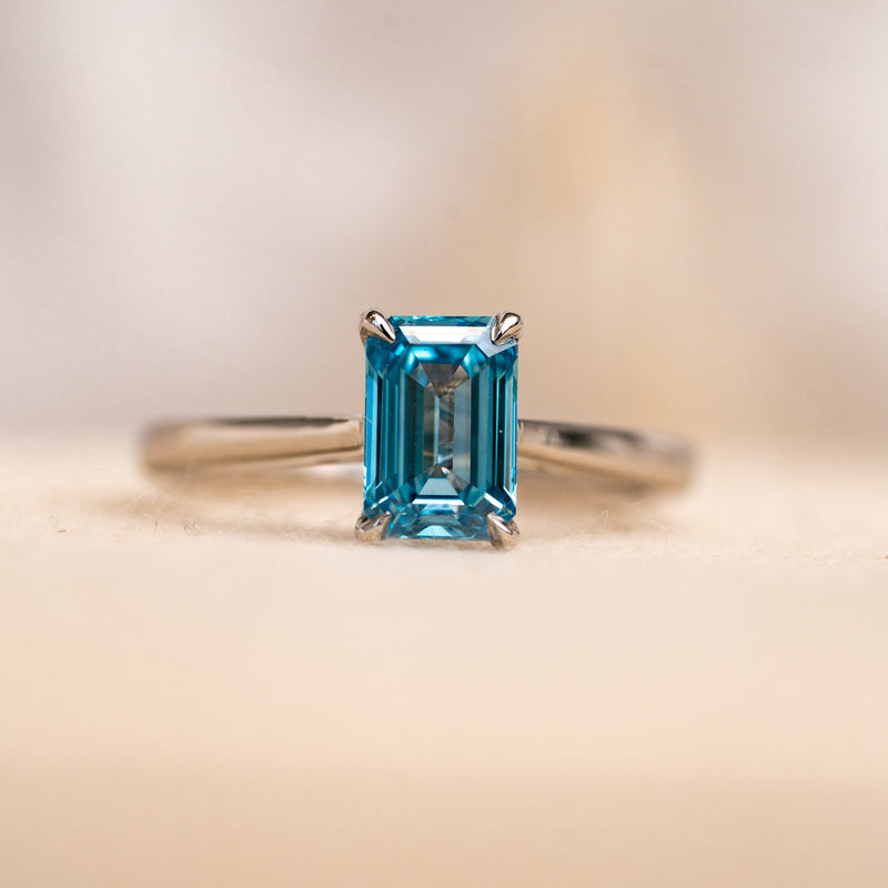 vivid Sapphire blue diamond ring with lab grown emerald cut diamond set into recycled platinum