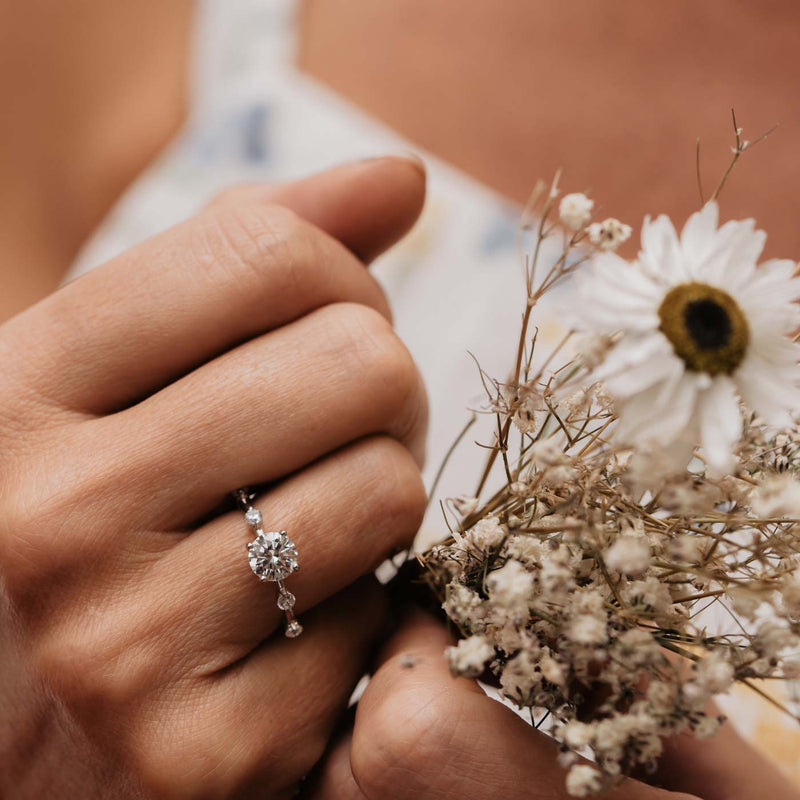 model holds bouquet of flowers wearing unique station ring