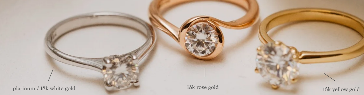 Metal comparison showing platinum/18k white gold, 18k rose gold, and 18k yellow gold rings