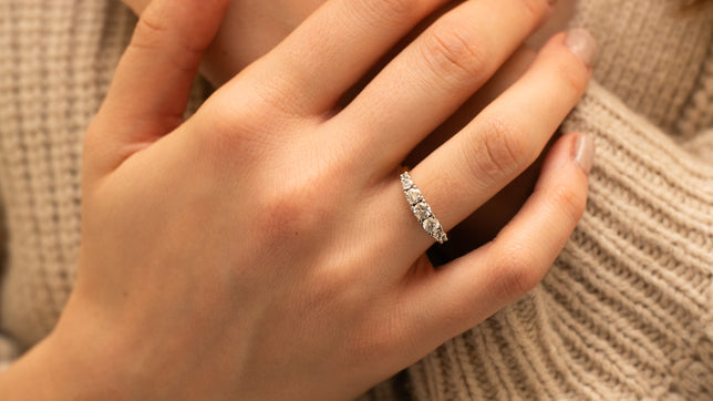 Toi et moi two stone lab-grown diamond ring worn on women's hand, brown hair can be seen in background. 