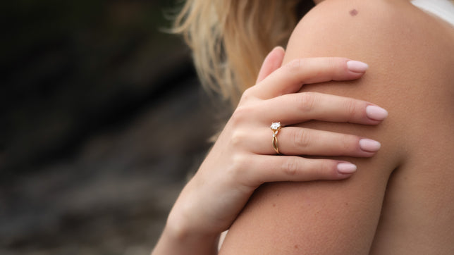 Close up of solitaire moissanite oval engagement ring worn on hand