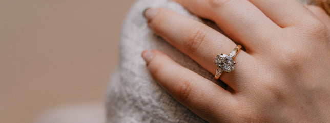 Close up of woman wearing a three stone ring in gold