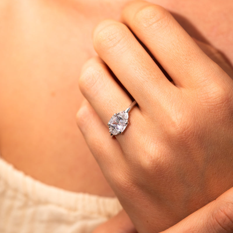 half moon and emerald trilogy ring on hand by Ethica Diamonds