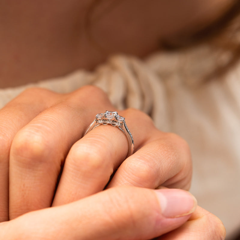 Close-up of Beatrix Ring showcasing central diamond, side stones, and sparkling hidden halo