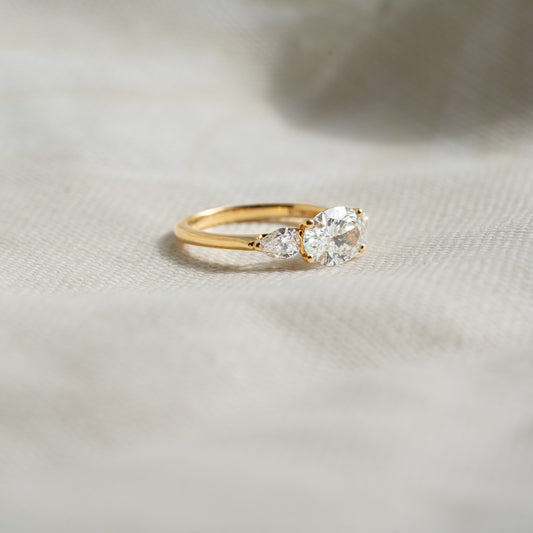 Side view of Claire Ring displaying oval center diamond with pear side stones for symmetry