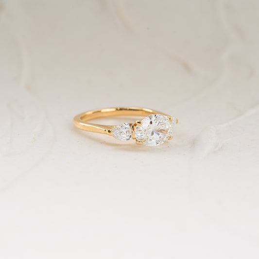 Side view of Claire Ring displaying oval center diamond with pear side stones for symmetry