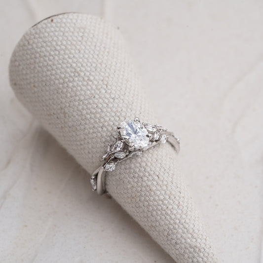 Large big presence engagement ring with nature inspired design and 4 talon claws securing centre oval
