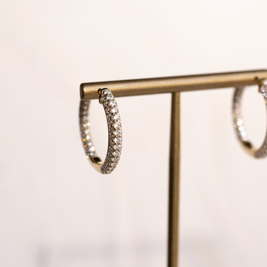 Diamond hoops on a gold stand against a light background