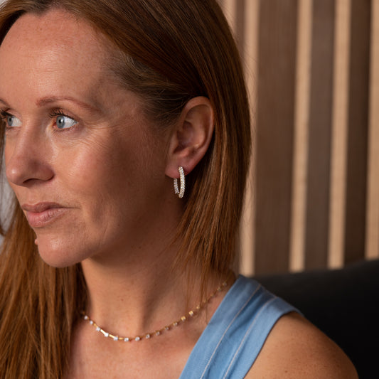 Side view of medium pavé hoop earring highlighting hidden row