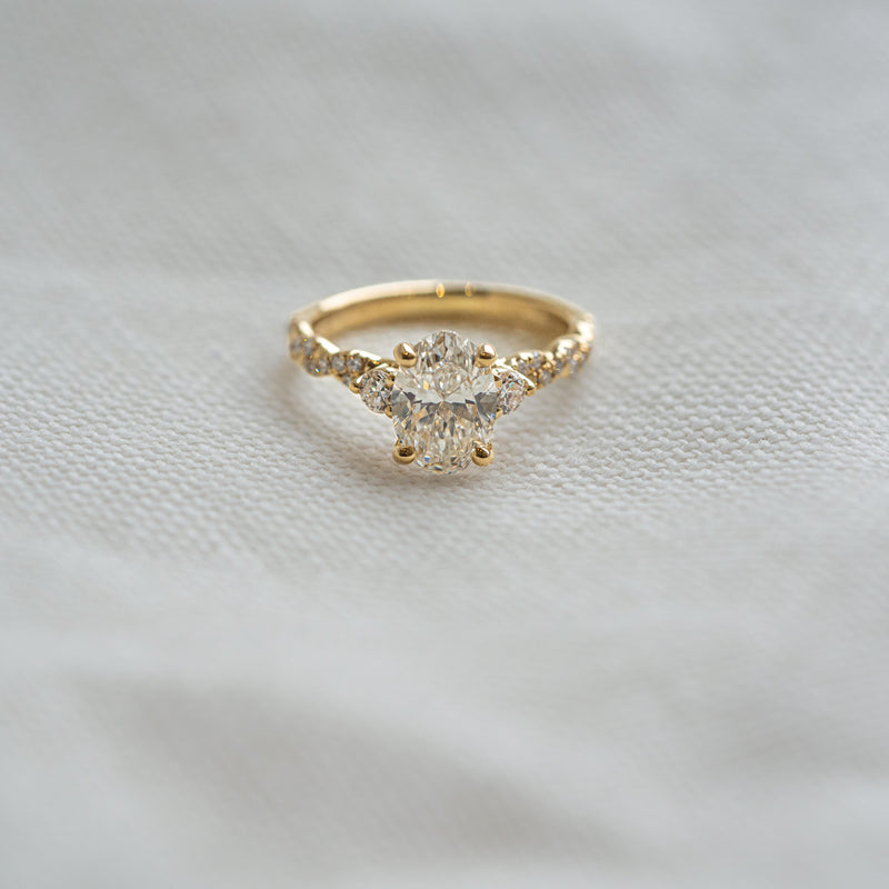 Gold ring with a diamond on a light gray fabric background