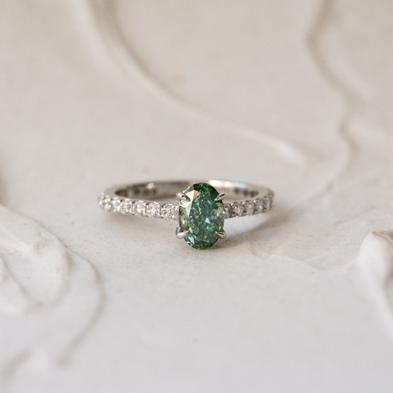 oval cut green diamond solitaire engagement ring with shoulder set hidden halo diamonds