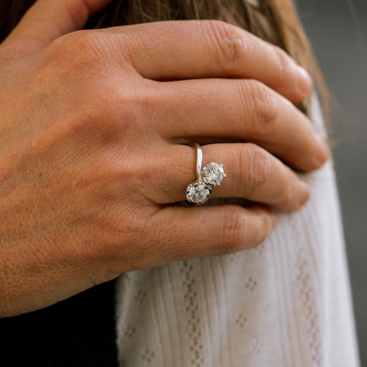 Close-up of a hand wearing an engagement ring by ethica diamonds in cornwall with a blurred background