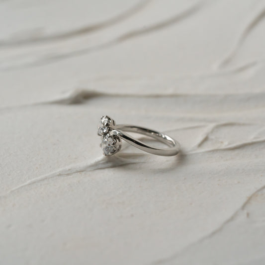 Silver ring with small diamonds on a light marble surface