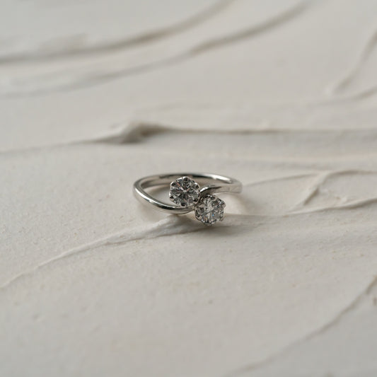 Engagement ring with lab diamond stones on a textured beige surface
