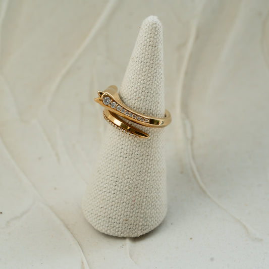 Gold horse head ring with small diamonds on a textured white stand