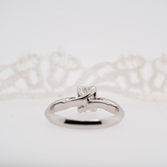 Silver ring with a diamond on a light gray background with twisted shank detail