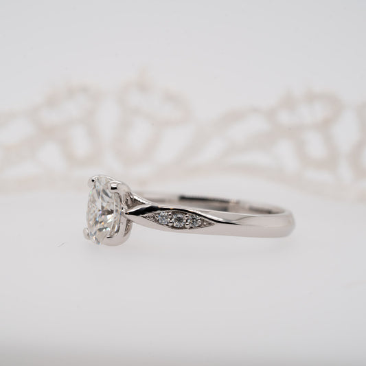 knife edge solitaire engagement ring with shoulder set diamond melee against white background