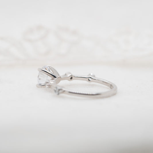 Silver ring with a heart-shaped diamond on a light gray background
