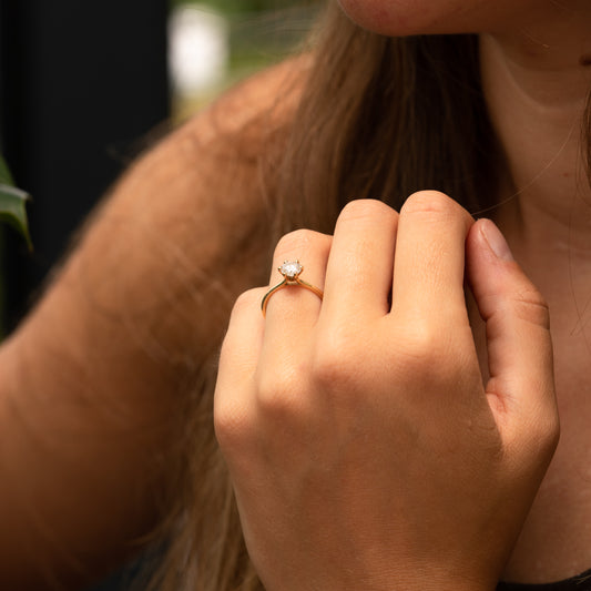 Model wears tall open basket engagement ring with 6 prongs and open daylight shoulders 