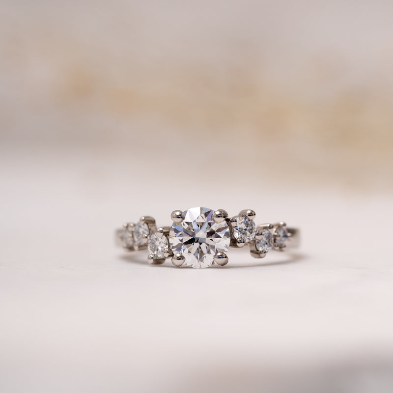 The sophie by ethica diamonds is an asymmetrical diamond engagement ring with round centre and round accented diamonds