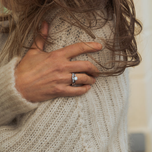 Model wearing sustainable nature themed bridal set, solitaire engagement ring with marquise round wedding band