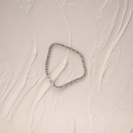 Silver beaded bracelet on a textured beige surface