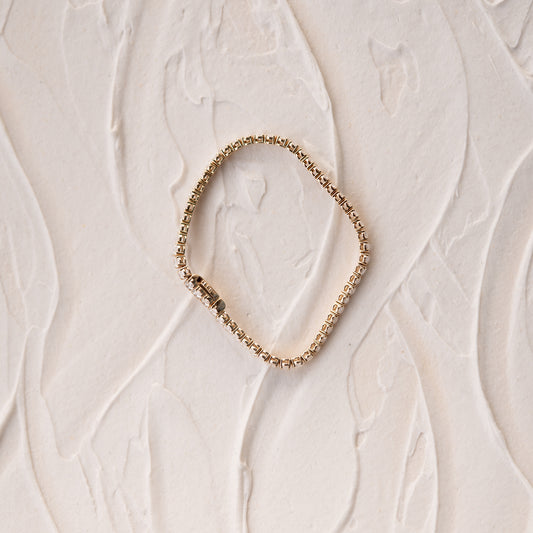 Close-up side of yellow oval lab diamond tennis bracelet on a texture background