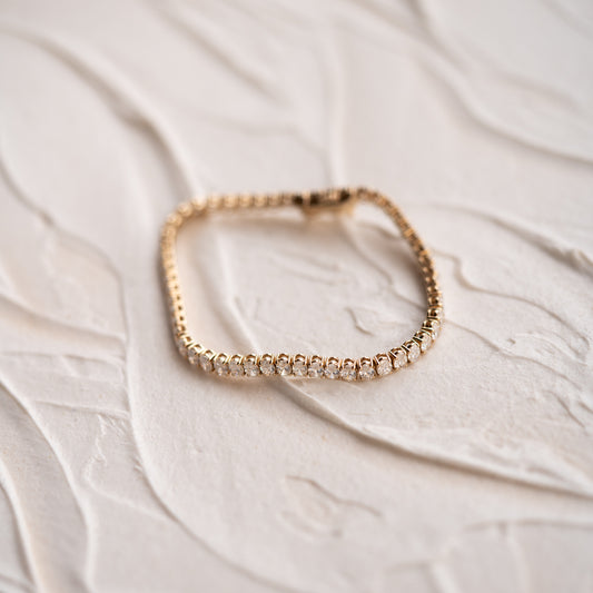 Rose gold bracelet on a textured white surface