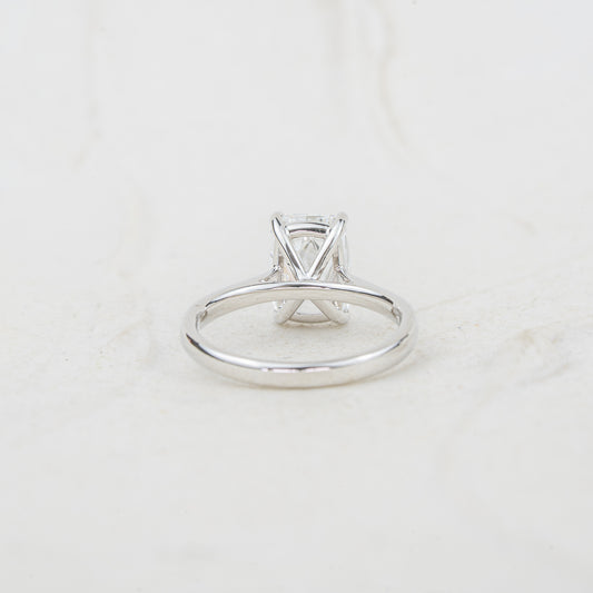 Daylight shoulders shown as part of 4 claw open basket setting with gallery rail beneath centre stone against white textured background