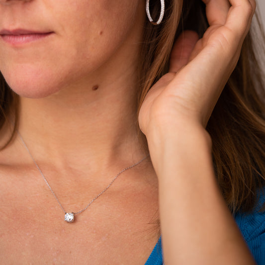 Close-up of a woman wearing an Ethica Diamonds necklace with a round diamond pendant. Made in Cornwall