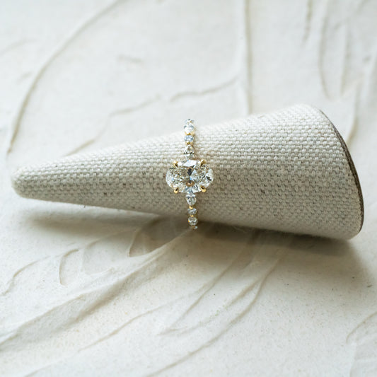 thin band oval engagement ring made in cornwall. Marquise and round accents on shoulders 