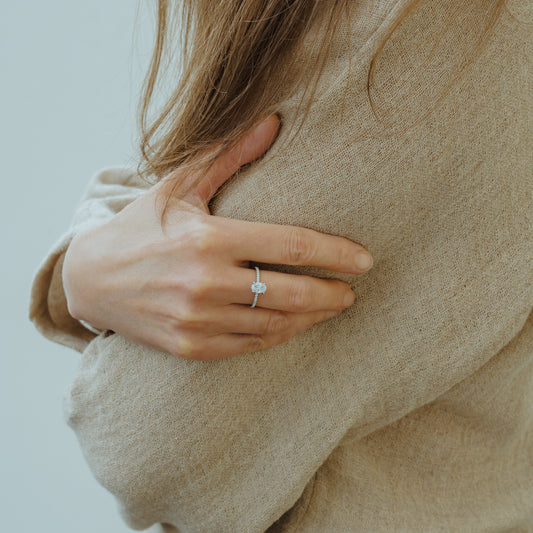 Sustainable lab grown diamond Nuki engagement Ring, by Ethica Diamonds worn on hand, showcasing oval cut and accent stones.