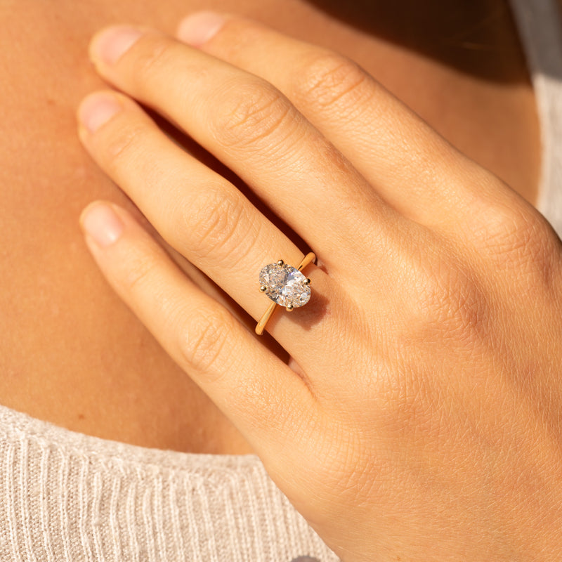 2.15ct penelope by ethica diamond solitaire oval engagement ring thin band on hand lifestyle photo