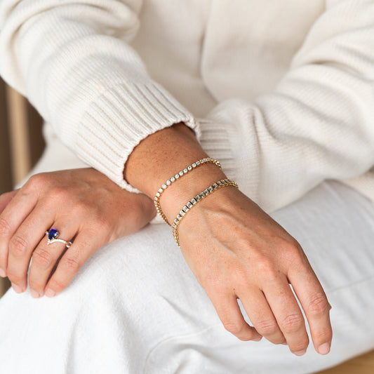 model wearing Jam Industries Cotton Knit Guernsey and a Bezel-set emerald diamond tennis bracelet in polished 9k gold.