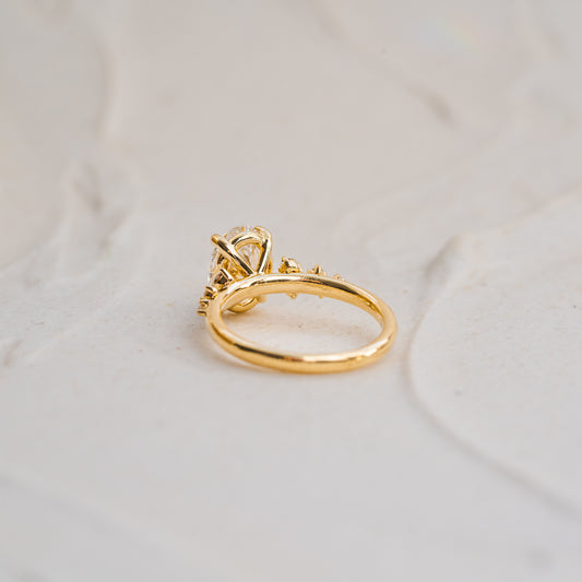 Gold ring with a diamond on a light beige background