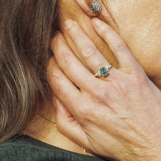 Model wears recycled yellow gold single centre diamond engagement ring with scattered side stones on band