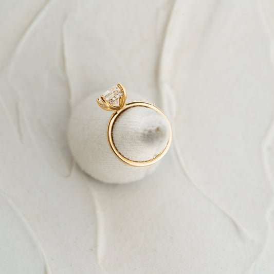 Photo of yellow gold engagement ring with mele stones set into claws elongated cushion diamond engagement 