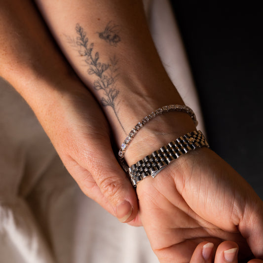 Wrist view of The Soraya 7.0ct emerald diamond bracelet by Ethica Diamonds, showing floral bee tattoo 