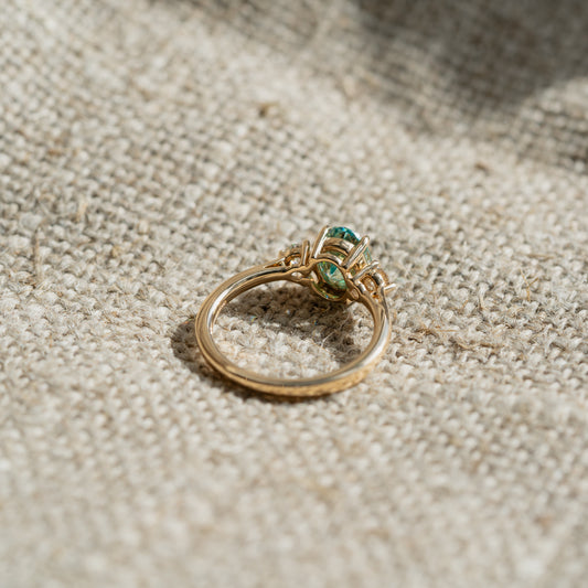 flat lay of 9k gold ring with moissanite in aquamarine and diamond engagement ring 
