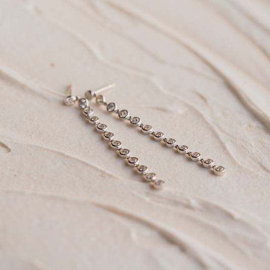 Silver chain earrings on a beige fabric background. Made in Cornwall. Sustainable Jewelery