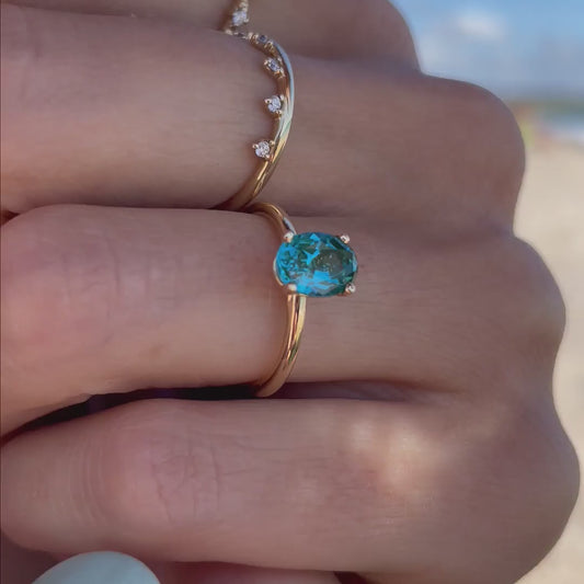 View of model wearing the The Alice teal hued 1.50ct  Paraíba Spinel Oval Four Claw Solitaire Ring by Ethica Diamonds 