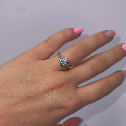 Video of model wearing sparkling round brilliant diamond ring with green halo and yellow gold band